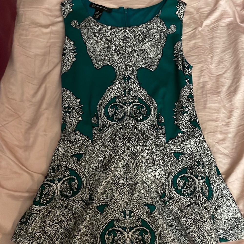 INC black and white design on green peplum top. Zipper in back. Size small